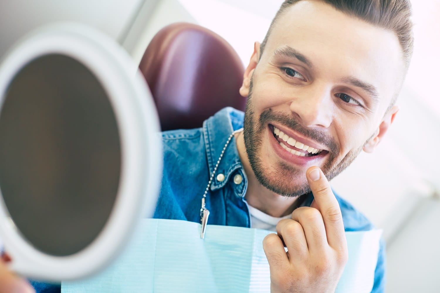 Man checking teeth in the mirror - Dental Implants in San Mateo