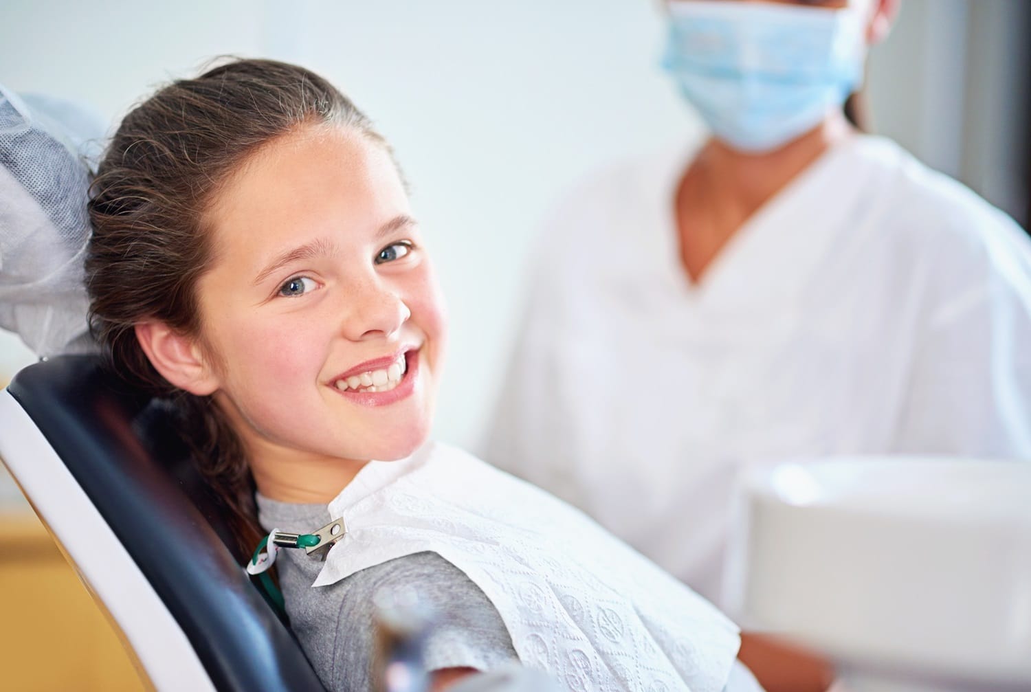 Happy young girl sitting in dental chair during checkup – Pediatric Dentist San Mateo
