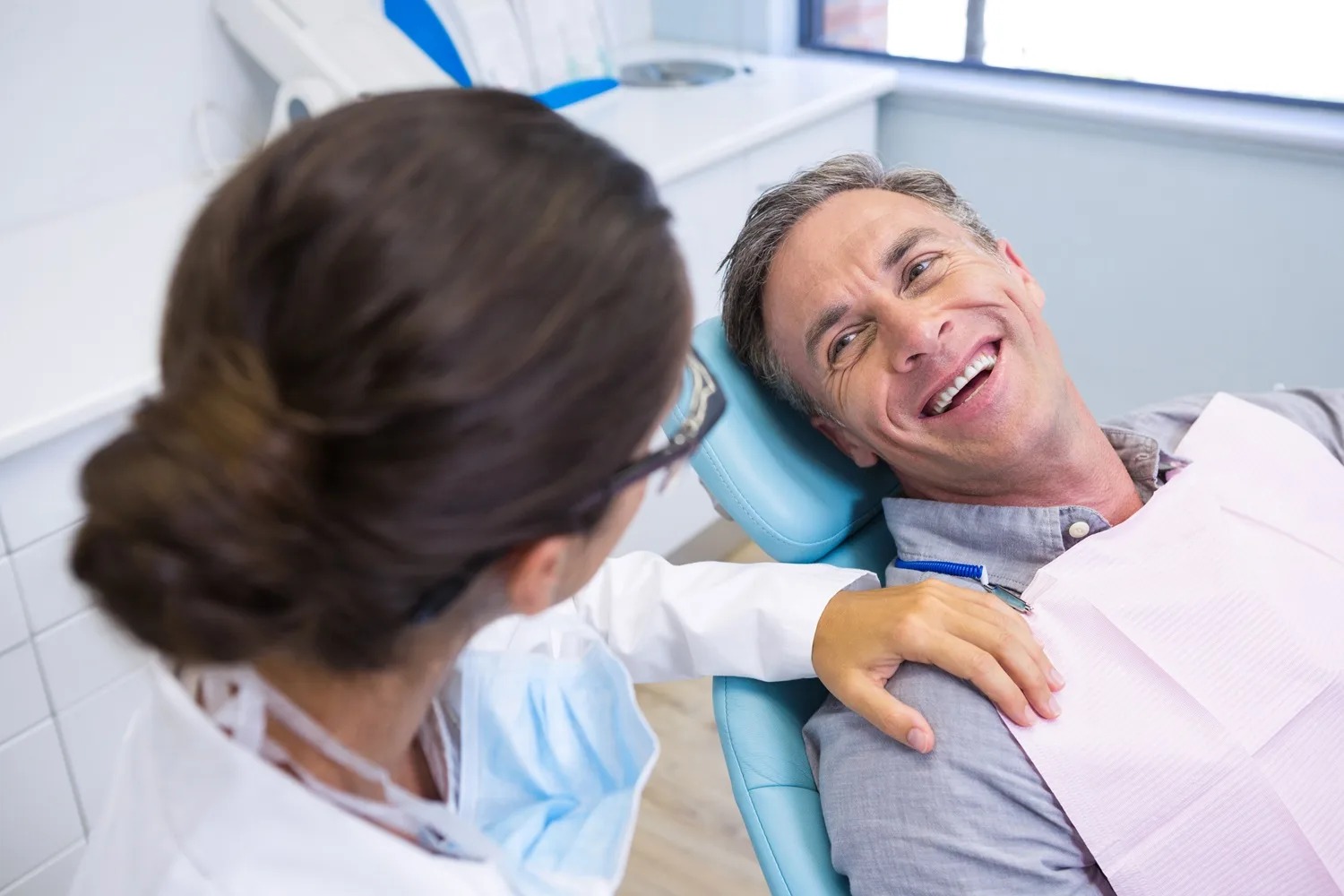 Friendly Dental Visit Experience – Dentist in San Mateo Smiling man sitting in a dental chair talking with a dentist, showing comfort and trust during a checkup — Dentist in San Mateo