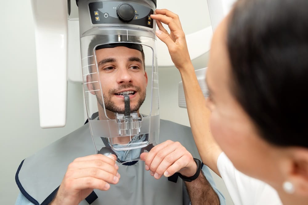 Advanced Dental X-Ray Imaging – Dentist in San Mateo Male patient undergoing panoramic dental X-ray scan with assistance from a dental professional — Dentist in San Mateo